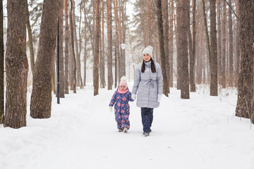 Fototapeta na wymiar Motherhood, children and nature concept - Attractive young woman and adorable child walking in park