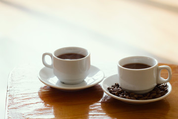 soft focus white coffee cup on a wooden table natural morning light vintage toned