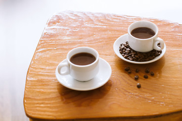 soft focus white coffee cup on a wooden table natural morning light vintage toned