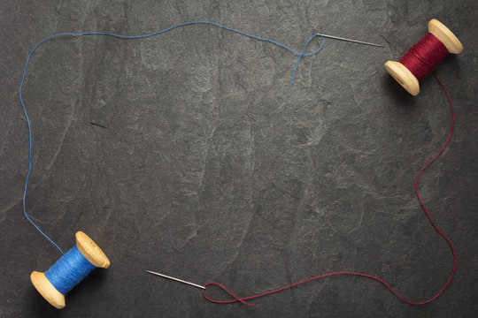 Spool Of Thread And Needle On Slate Stone