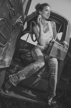 Black and white photo of girl with vintage radio near retro truck