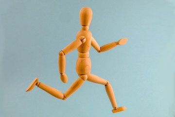 Wooden dummy running on light blue background