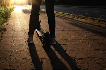 a girl with electric scooter on sunset © Andriy