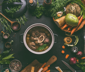 Cooked beef meat shin with bone in cooking pot on dark kitchen table background with low carb...