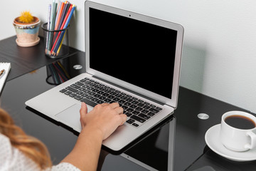 Close up of hands typing on a laptop in a coffee shop