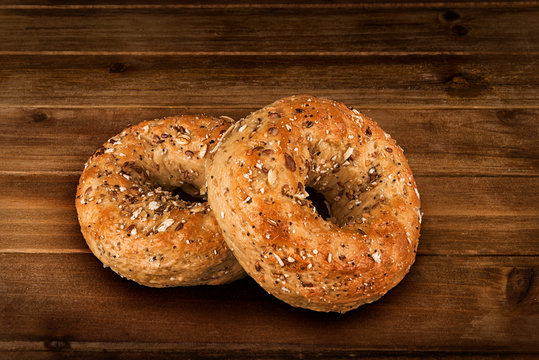 Close up on a set of multigrain bagel. Isolated on wooden plank background.