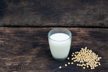 Soy milk and soy bean on wooden table and dark rustic kitchen background. Alternative milk concept.  selective focus