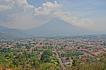Stadt in einem Tal und Vulkan im Hintergrund