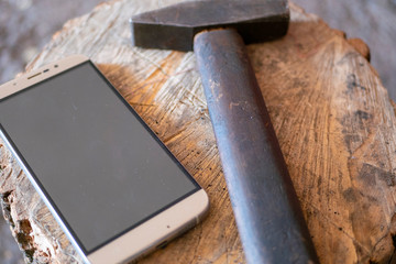 a hammer lies next to a mobile phone