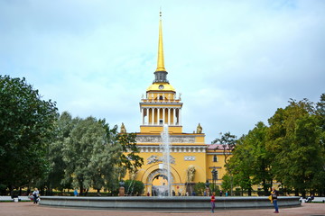 Landmark of St. Petersburg, Russia &ndash; yellow fa&ccedil;ade of admiralty house with arch, tower and  gold spire and fountain. Front view