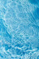 Background of rippled pattern of clean water in a blue swimming pool
