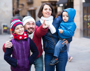 Man showing landmark for family at city