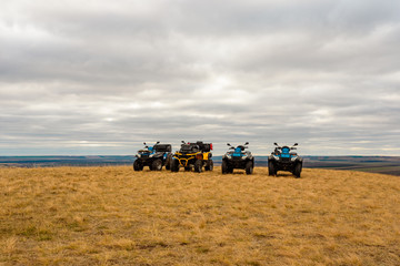 Fototapeta premium ATVs in the field in the highlands, on cloudy day