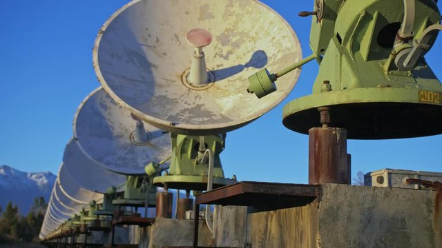 Hacker hacks the radio telescope using notebook. Man to program hacking on laptop in nature. Terrorist is hiding in camouflage balaclava. Hacker has criminal cases on the Internet. Programmer uses a