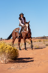 native american woman riding horse in desert