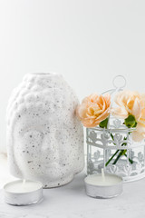 white ceramic figurine Buddha head  ,decorative cage with flowers and candles