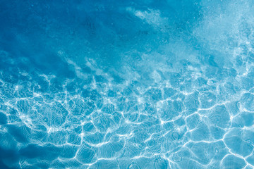 Background of rippled pattern of clean water in a blue swimming pool.