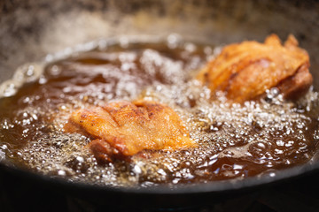 Fried chicken in hot oil and boiling in pan