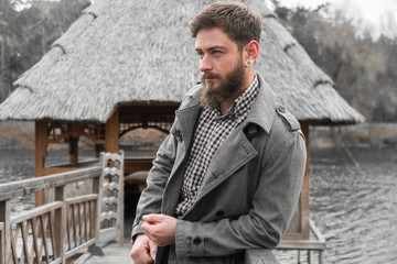 a man stands on the banks of the river. handsome man in the Park. autumn walk in the nature.