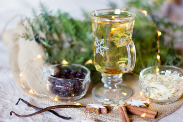 Glass with white bright mulled wine with raisins and almonds as hot drink for the festive season....
