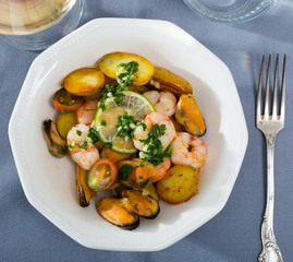 Delicious  warm salad of  shrimps, mussels and  fried new potatoes