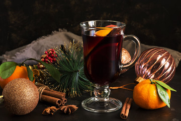 Christmas hot mulled wine with cinnamon and orange on a dark table. Selective focus.