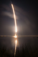 fire trail of a rocket taking off in a hazy night sky
