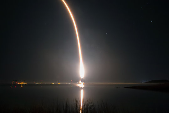 fire trail of a rocket taking off in a night sky