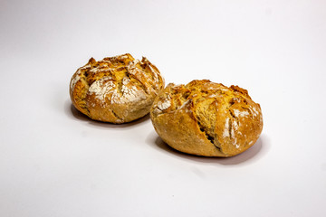 Two rustic bread rolls against white background