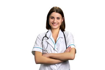 Young cheerful doctor on white background. Female medical worker standing with arms folded. Pretty female practitioner.
