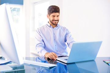 Sales man with laptop working in the office