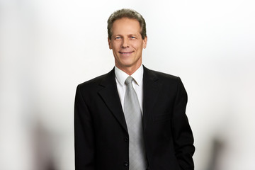Portrait of cheerful mature businessman. Middle-aged man in black business suit and tie is smiling,...