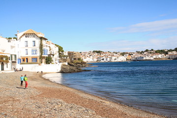 Fototapeta na wymiar Bright white buildings and blue details, Mediterranean village of Cadaques, the Pearl of the Costa Brava, Spain
