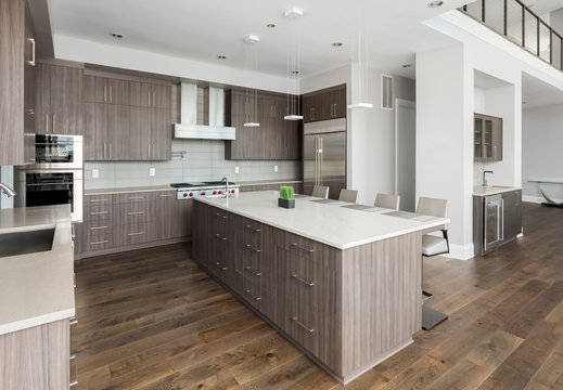Kitchen in New Luxury Home with dark cabinets and woodwork, and stainless steel appliances