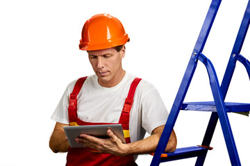 Portrait of architect working on pc tablet. Handsome engineer using portable tablet isolated on white background. People, constructions, modern technology.