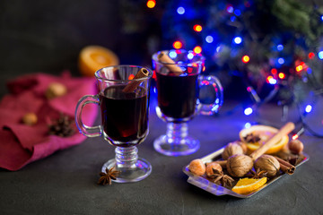 Red mulled wine in glasses with electric lights at dark background