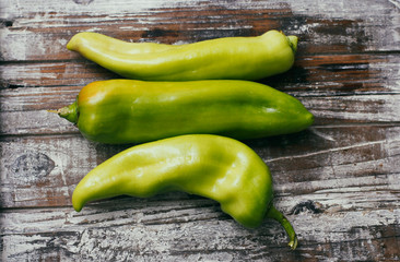 Set of green sweet peppers on wooden table. Fresh raw vegetables.