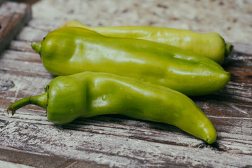 Set of green sweet peppers on wooden table. Fresh raw vegetables.