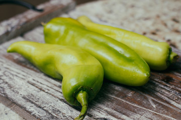 Set of green sweet peppers on wooden table. Fresh raw vegetables.