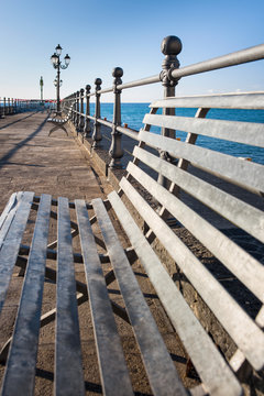 wide angle view to steel bench on the pier in port in Italy