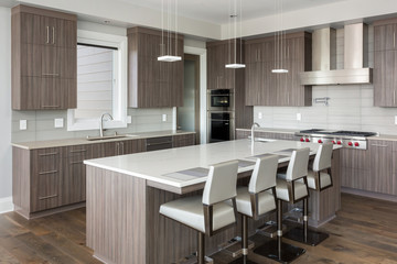 Kitchen in New Luxury Home with dark cabinets and woodwork, and stainless steel appliances