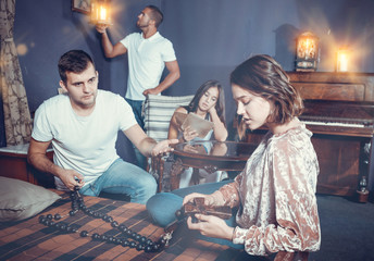 Young people with wooden rosary in escape room