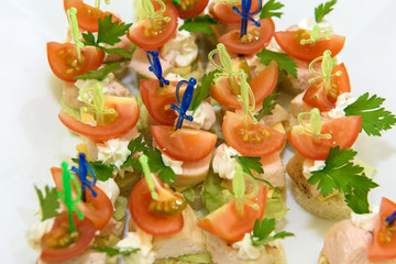 Canapes with cheese and tomatoes. Cold appetizer for wine at the party.  