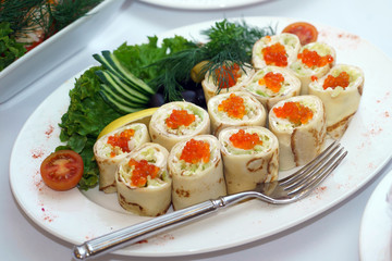 Rolls with red caviar on the holiday table. Gourmet gourmet food with exquisite decoration. 