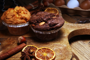 Chocolate muffin and nut muffin, homemade bakery wooden background