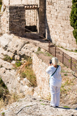 Fototapeta premium A woman in white on a cliff in the Siurana, Tarragona, Catalunya, Spain. Back view. Vertical.