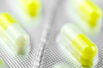 Packaging with yellow pills for treatment. Close up.