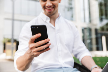 Happy young business man using mobile phone