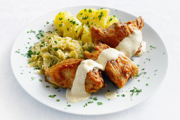 floured roasted rabbit with mustard based sauce garnished with potato and cabbage sprinkled with...