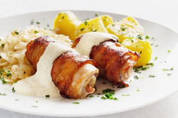 roasted roulade of rabbit belly and bacon under mustard based sauce garnished with vegetables
